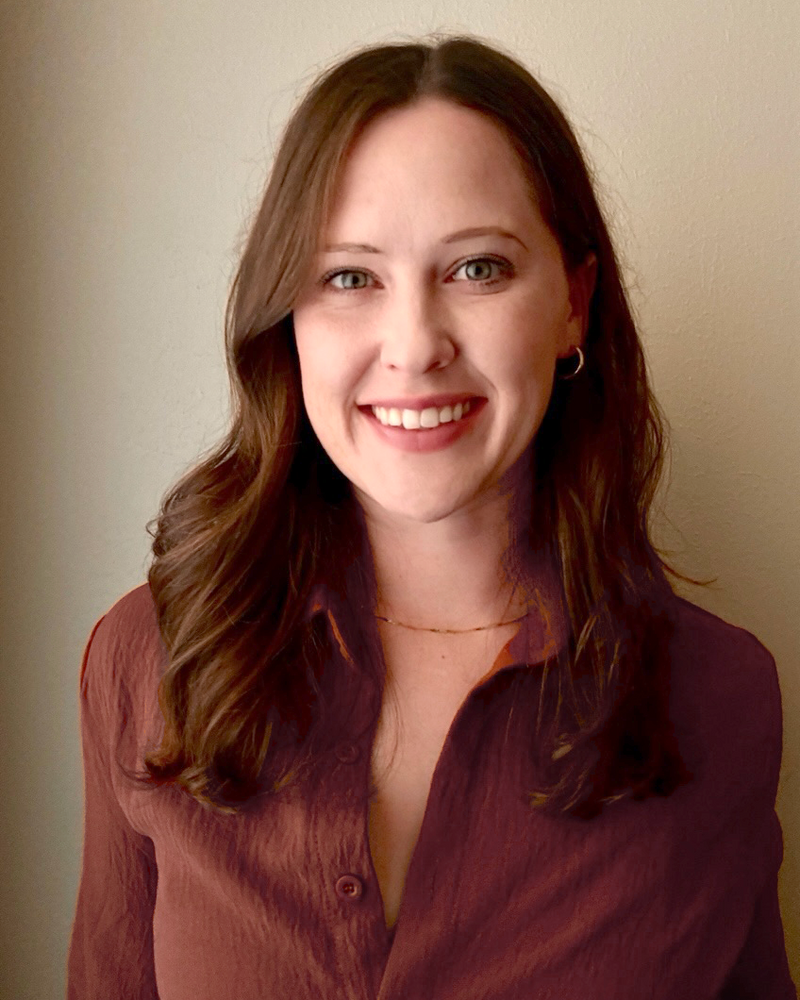 Ashley Edwards wearing a maroon shirt against a beige background